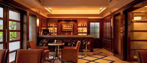 A bar area with a polished marble floor, wooden furniture, and a well-lit ambiance.