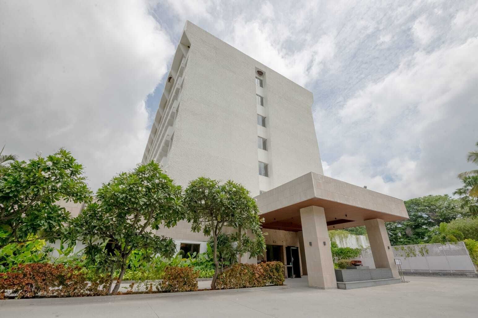 A tall, modern building with a flat roof and a covered entrance area.