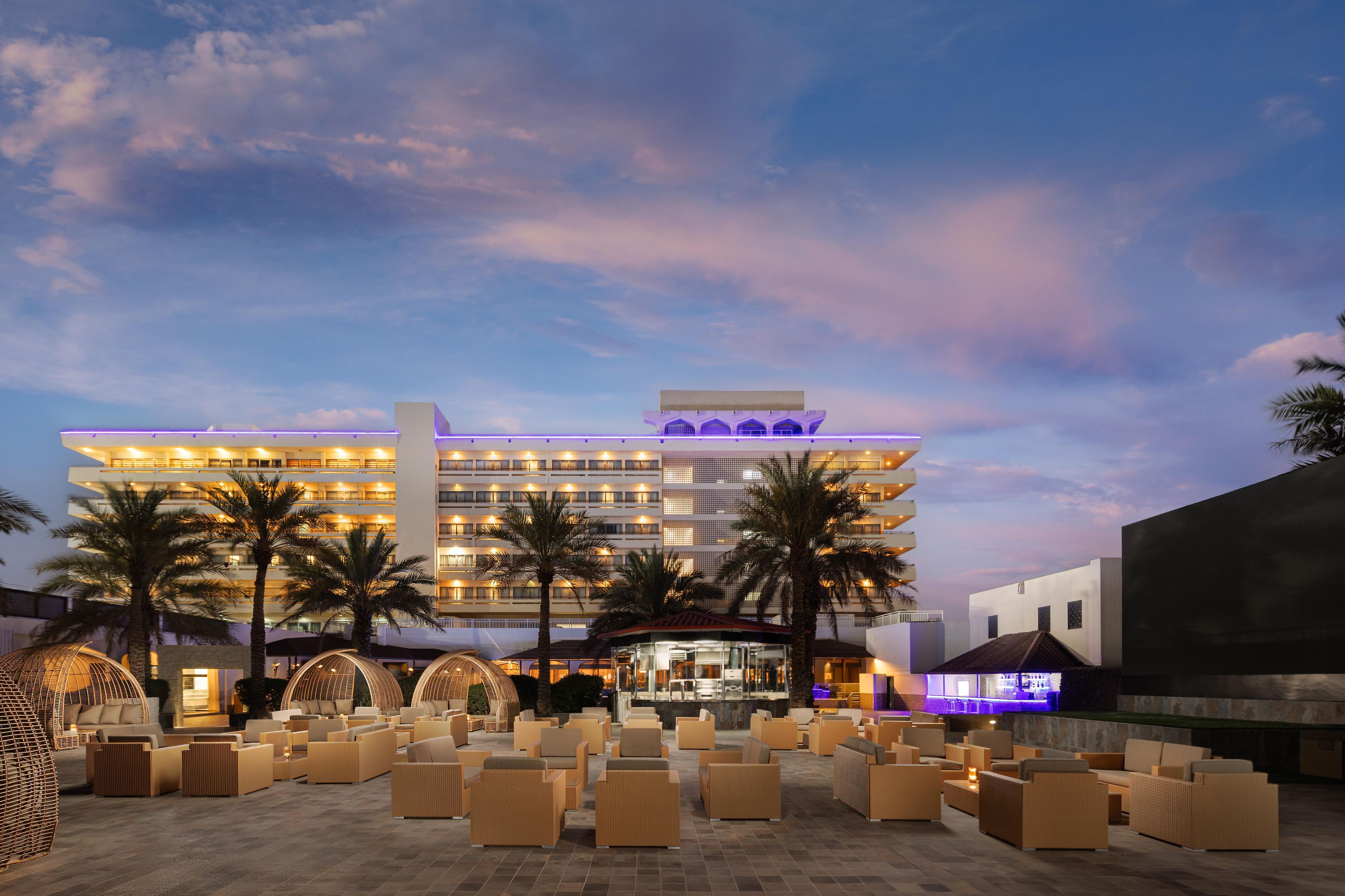 A hotel with multiple floors, outdoor seating areas, and a bar.