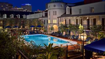 Een buitenzwembad, parasols voor strand/zwembad