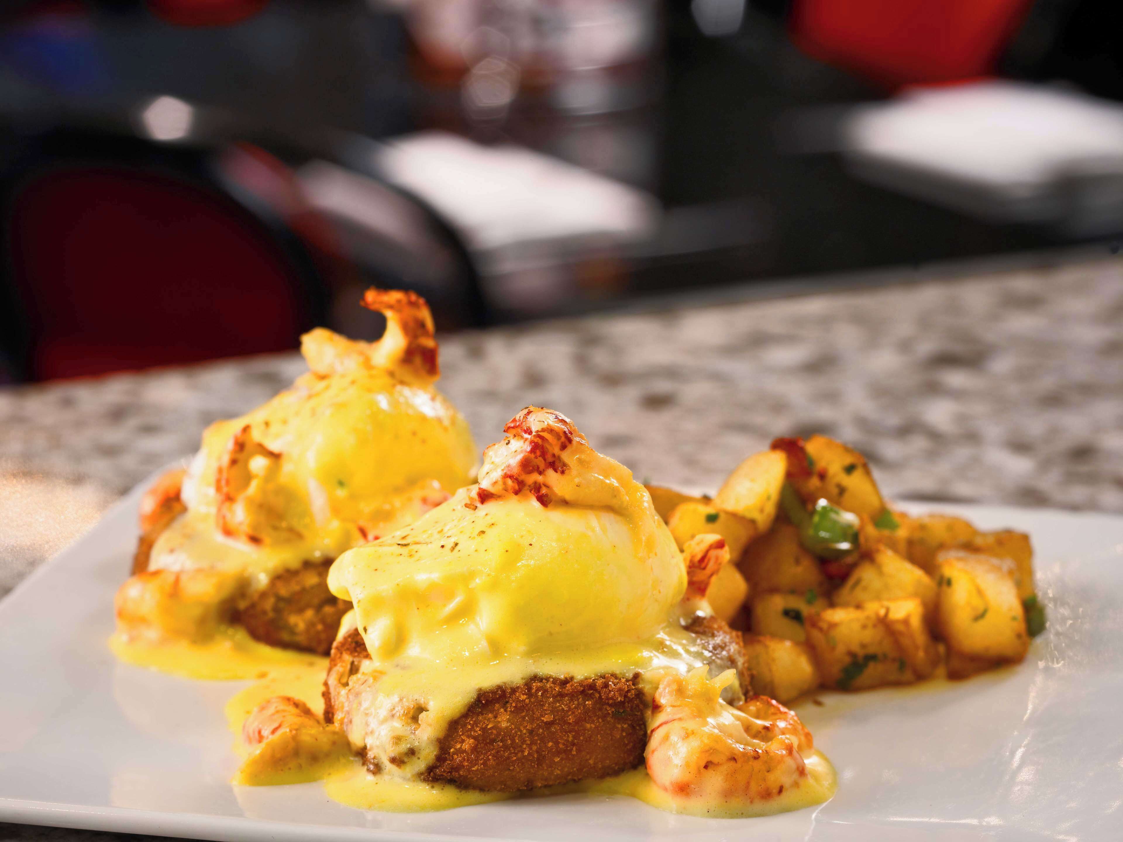Ein Teller mit Eggs Benedict und Kartoffeln.