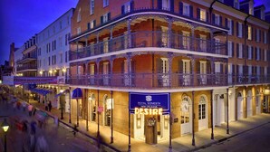 Ein mehrstöckiges Hotel mit Balkonen, eine Beschilderung für das French Quarter Festival und ein Restaurant namens Royal Sonesta Desire.