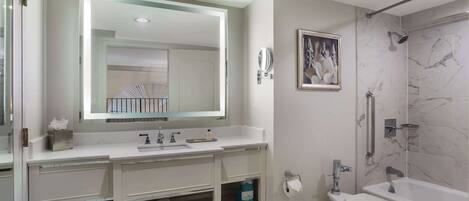 Un baño moderno con un espejo grande, una bañera, un inodoro y una ducha.