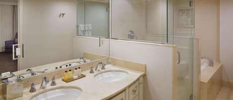 A bathroom with two sinks, a glass shower enclosure, and a large mirror.