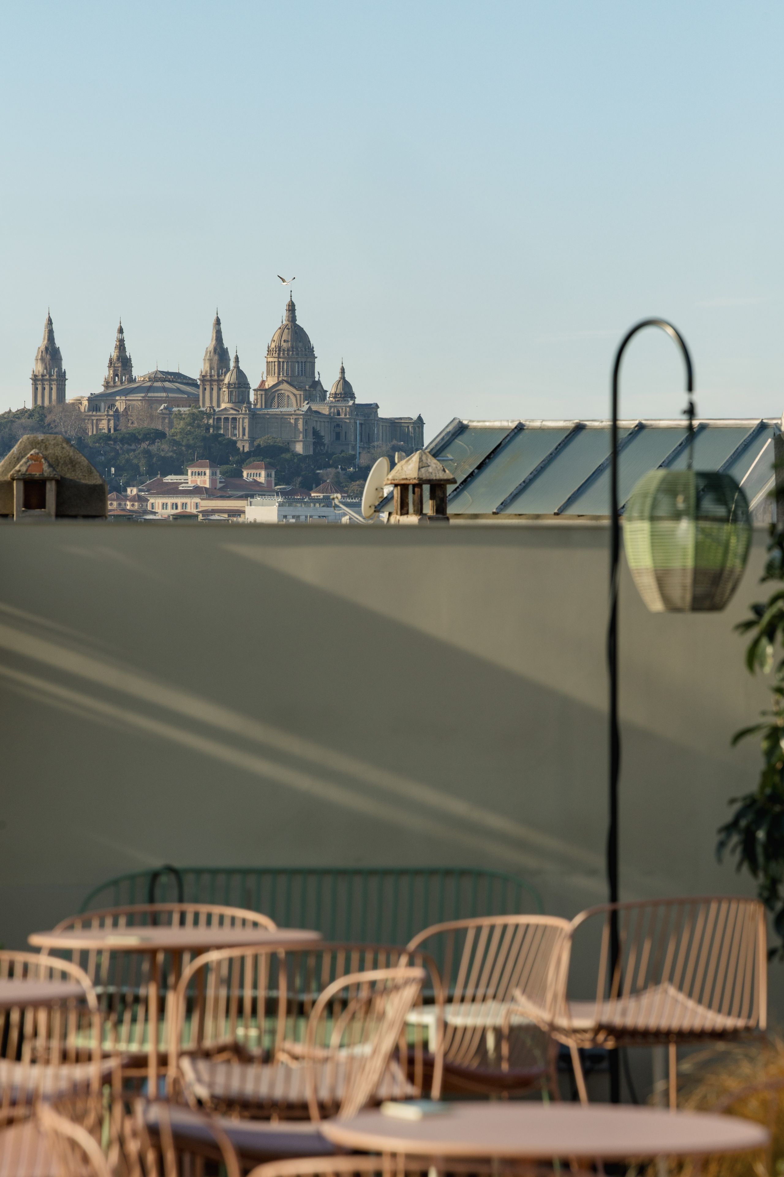 A terrace with outdoor seating and a view of a historic building with domes.