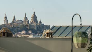 A terrace with outdoor seating and a view of a historic building with domes.