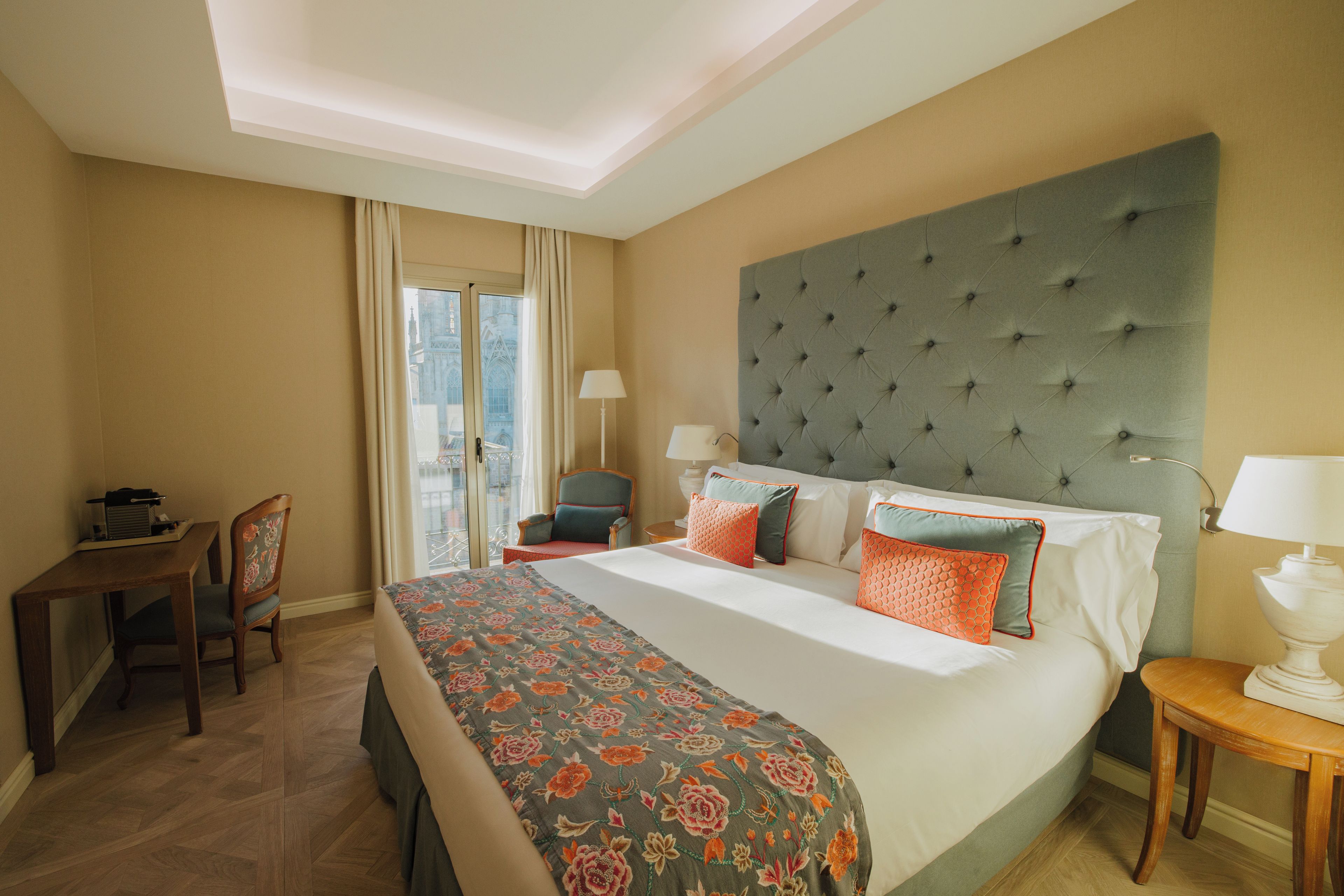 Een hotelkamer met een groot bed, een bureau en een stoel.