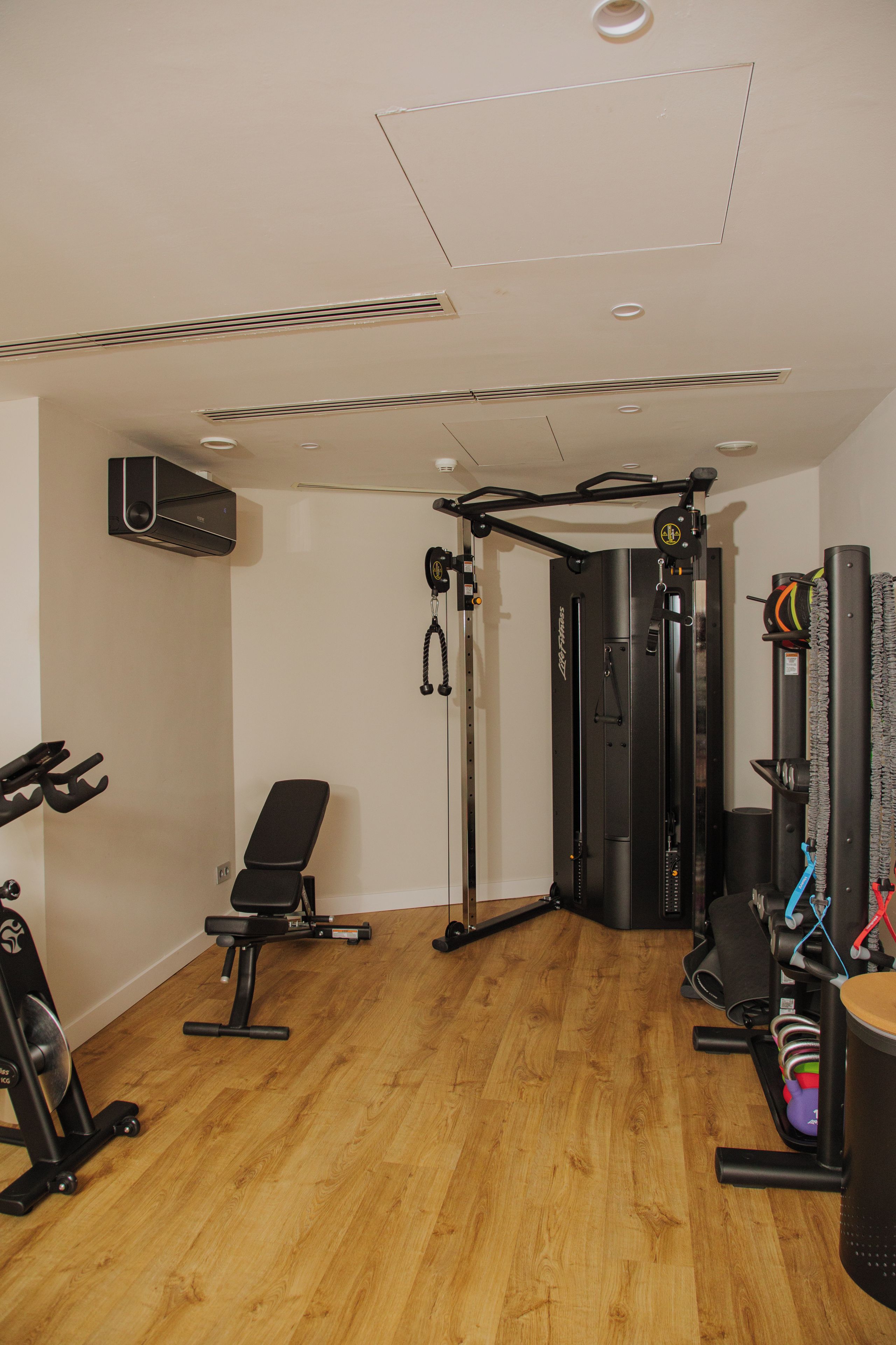 A gym with a pull-up bar, bench, and various exercise equipment.