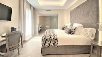 Una habitación de hotel moderna con una cama grande, un escritorio y un televisor.