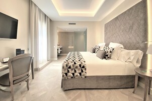 Una habitación de hotel moderna con una cama grande, un escritorio y un televisor.