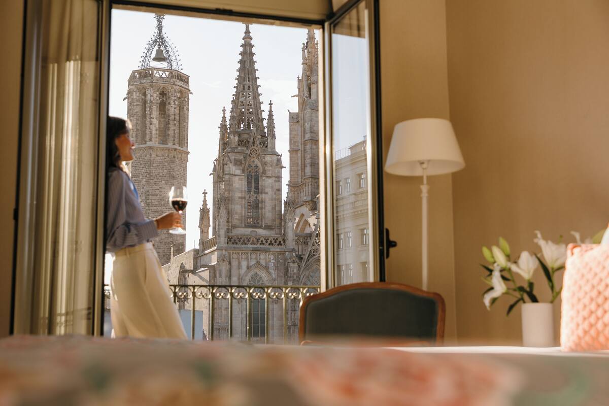 Quarto de hotel com uma grande janela que oferece vista para uma catedral histórica.