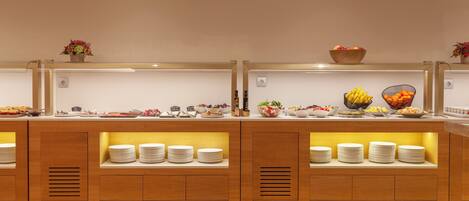 Uma mesa de buffet com diversos alimentos e acompanhamentos.