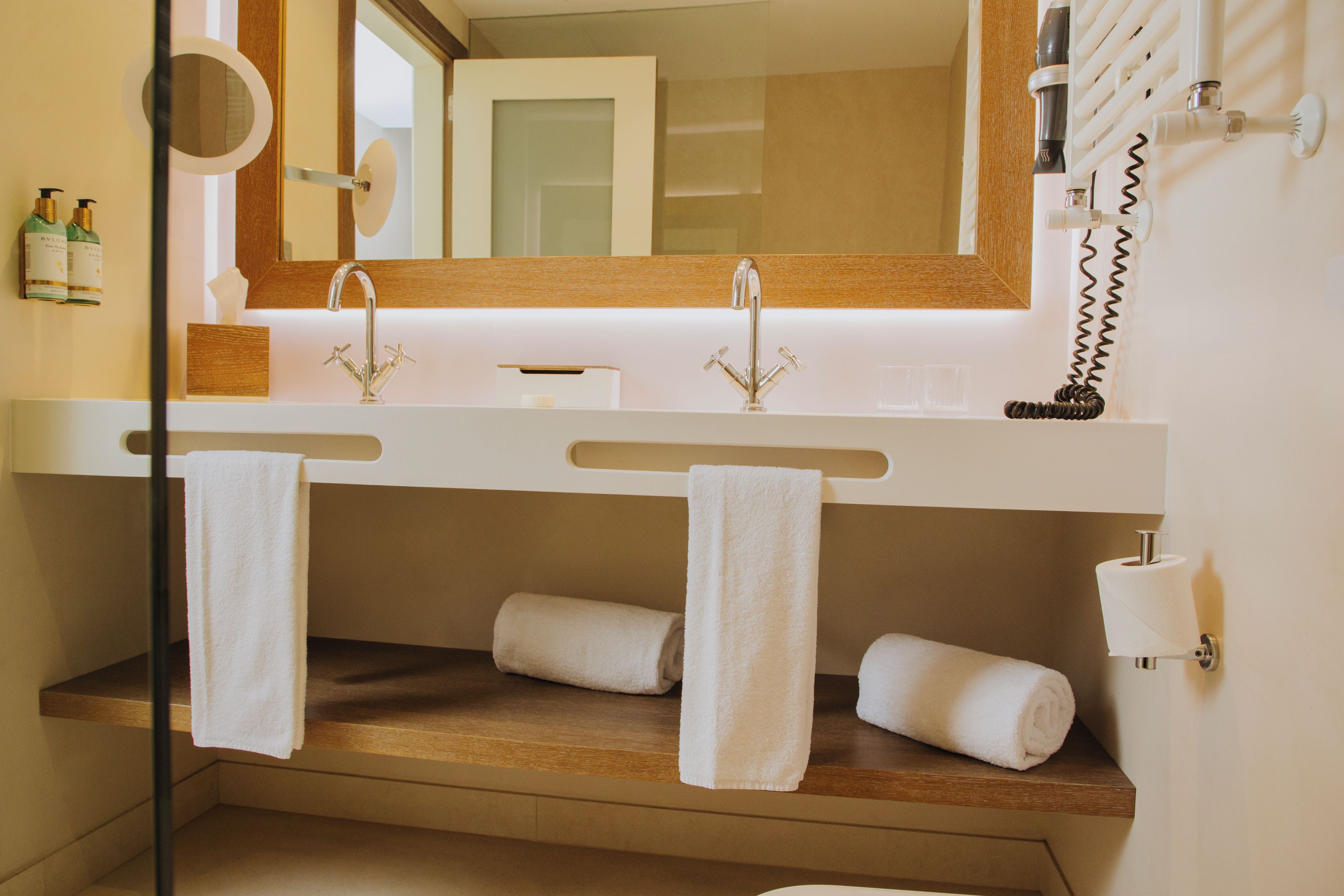 Ein Badezimmer mit zwei Waschbecken, einem Spiegel und Handtüchern.