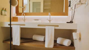 Un baño con dos lavamanos, un espejo y toallas.