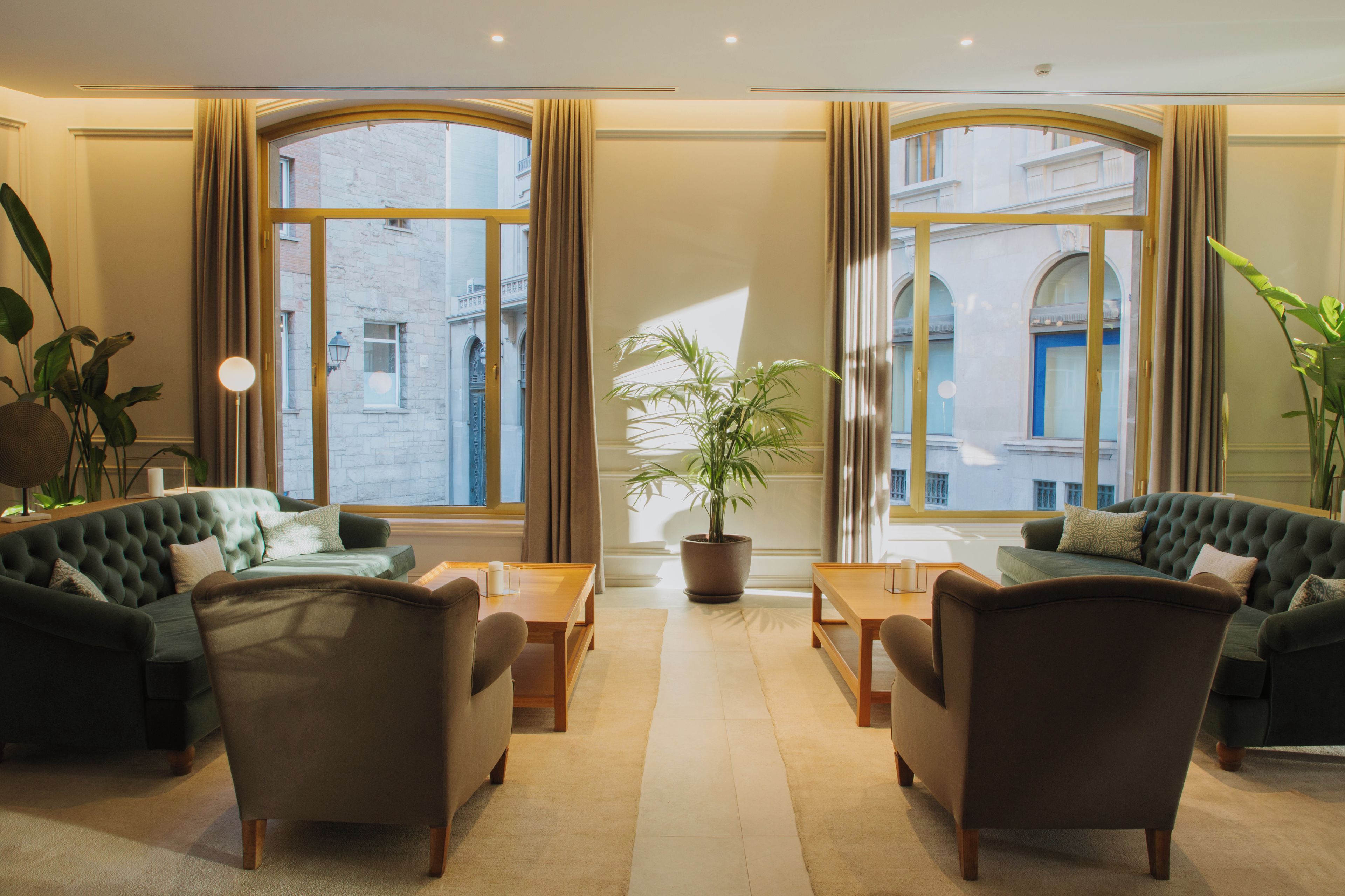 A hotel lobby with two sofas, a coffee table, and a potted plant.