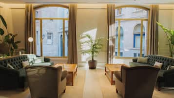 A hotel lobby with two sofas, a coffee table, and a potted plant.