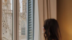 Una habitación con un amplio ventanal que da a un edificio histórico de arquitectura elaborada.