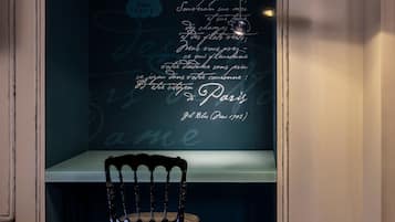 A wall with a quote in cursive script, a chair, and a table.