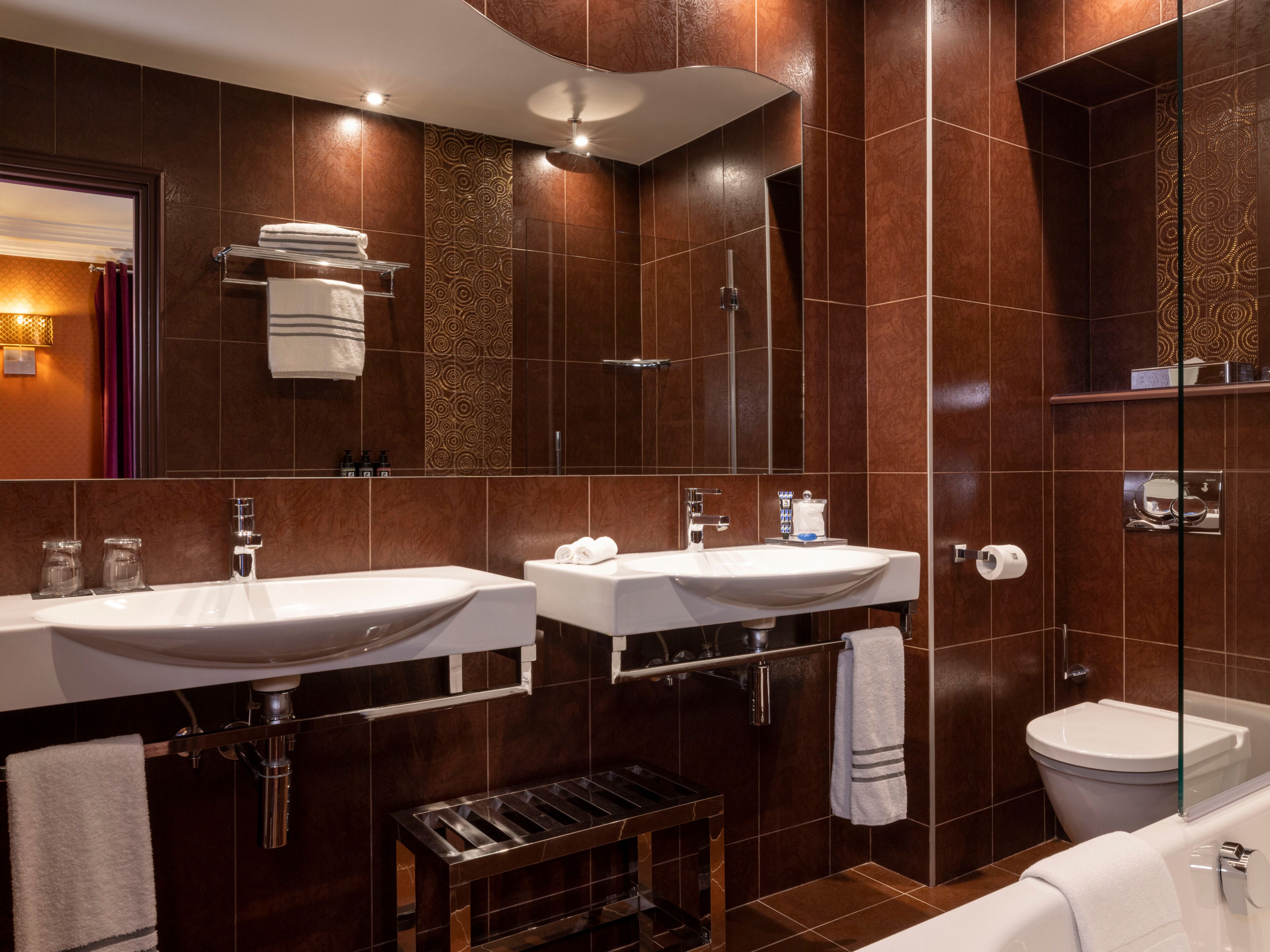Une salle de bain moderne avec deux lavabos, une douche et des toilettes.