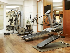 A gym with cardio equipment, dumbbells, and a mirror. - Hôtel Edouard 7 Paris Opéra (Paris)