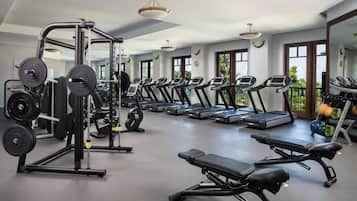 A gym with treadmills, weight machines, and benches.