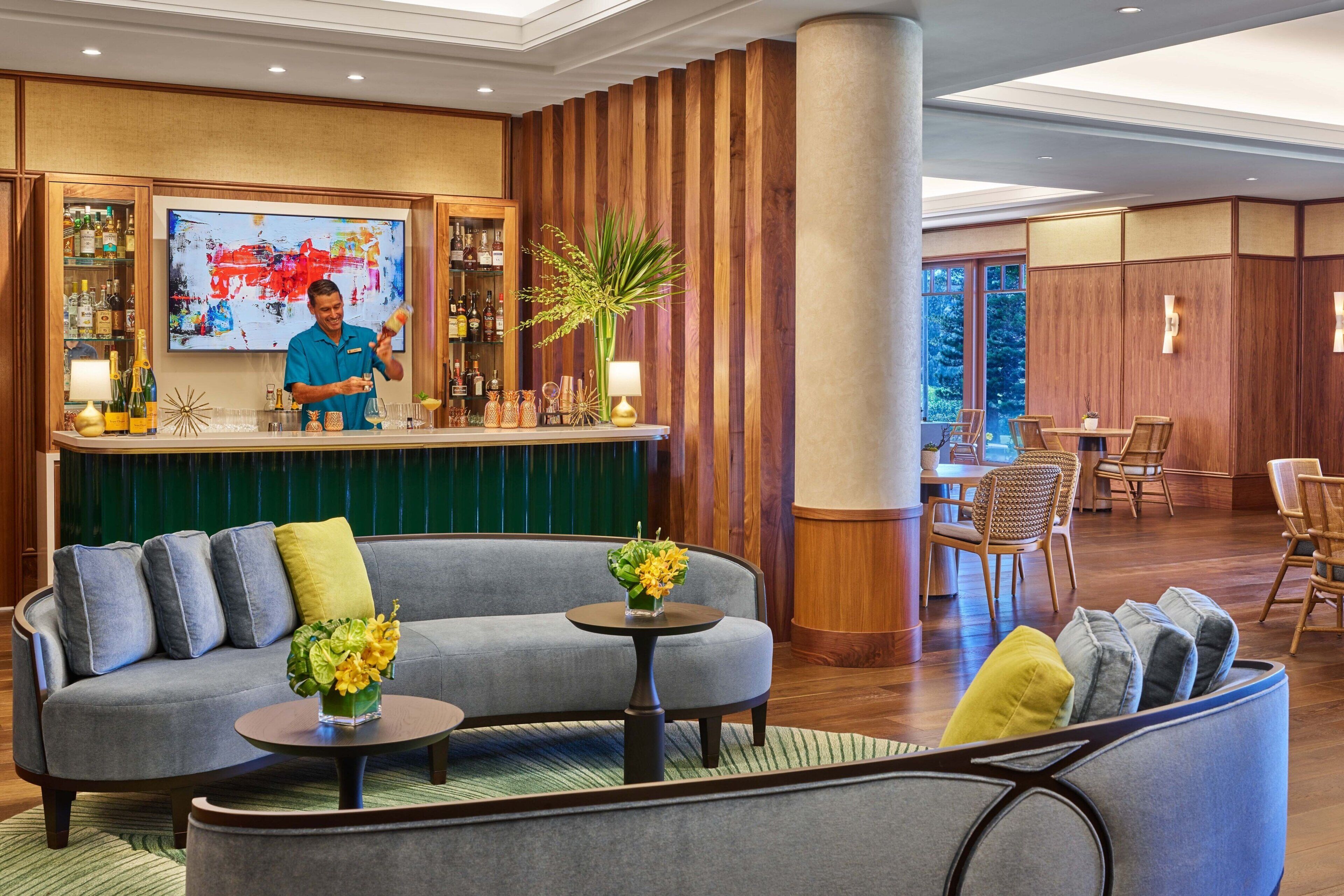 Eine Lobby mit Barbereich, Sitzgelegenheiten und einem großen Fenster.