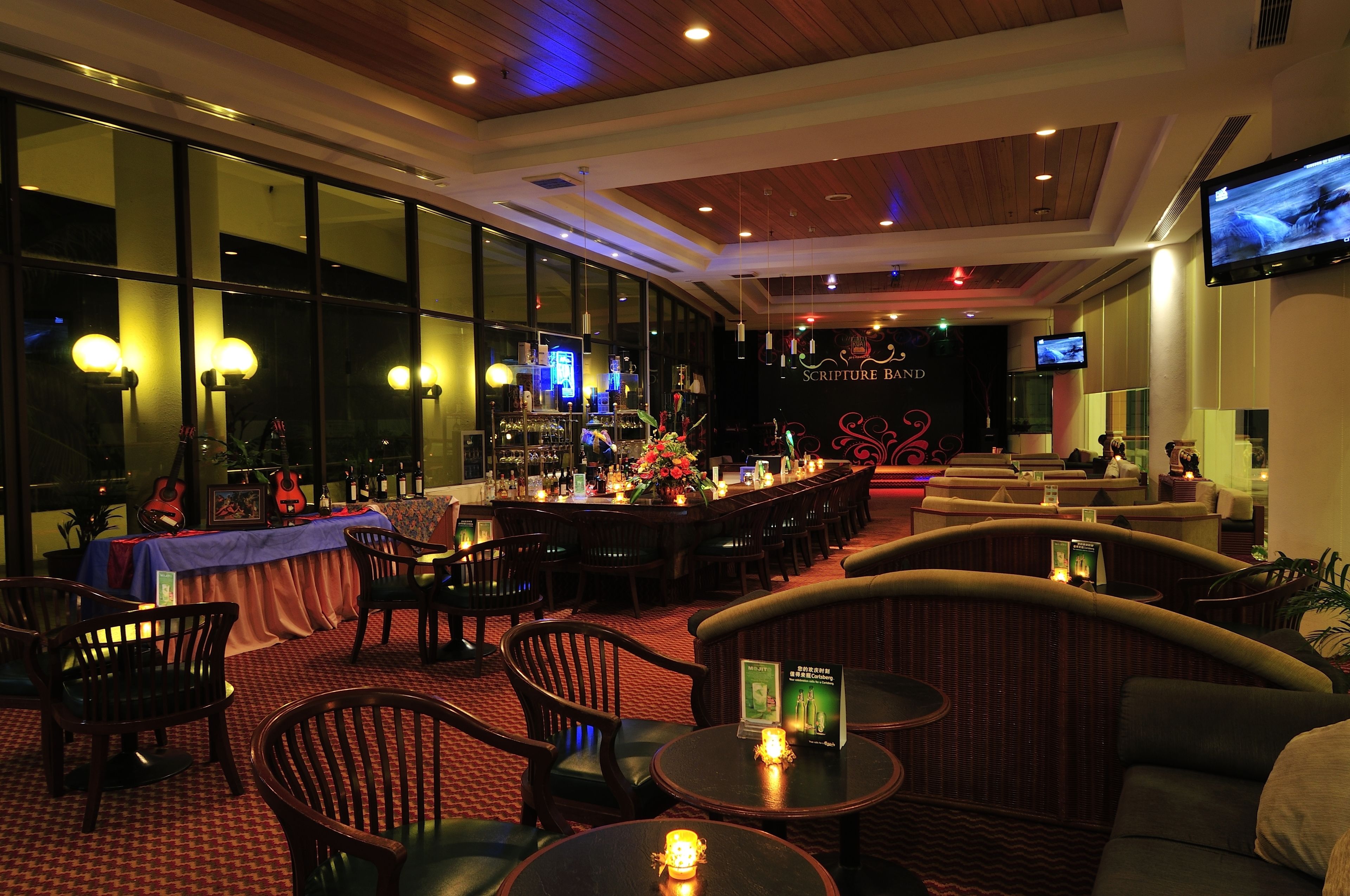 A bar area with tables, chairs, and a counter with a menu.