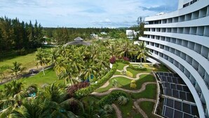 A modern hotel with a curved exterior, a landscaped garden with palm trees, and a pool area. - ParkCity Everly Hotel Miri (Miri)