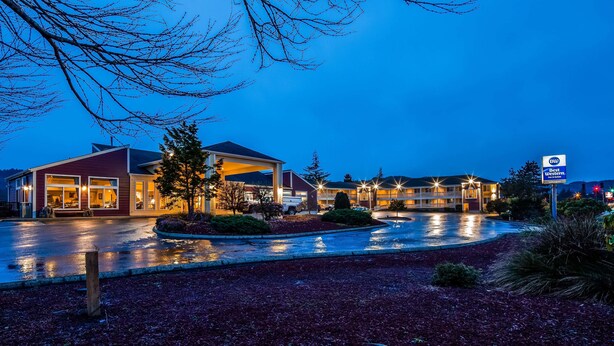 A hotel with a covered outdoor area, a parking lot, and a sign indicating it is a Best Western Inn & Suites.