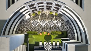 Una estructura arquitectónica moderna con una entrada curva, patrones geométricos en las paredes y una zona de estar central con suelo estampado.