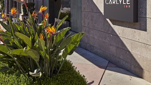 A building with a sign reading "Carlyle Inn" and a number "119" on the wall. - Carlyle Inn (Los Angeles)