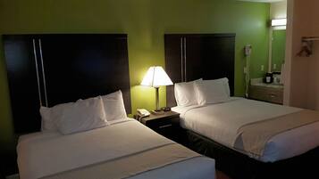 Ein Hotelzimmer mit zwei Betten, einem Nachttisch mit Lampe, Telefon und einer Kaffeemaschine.
