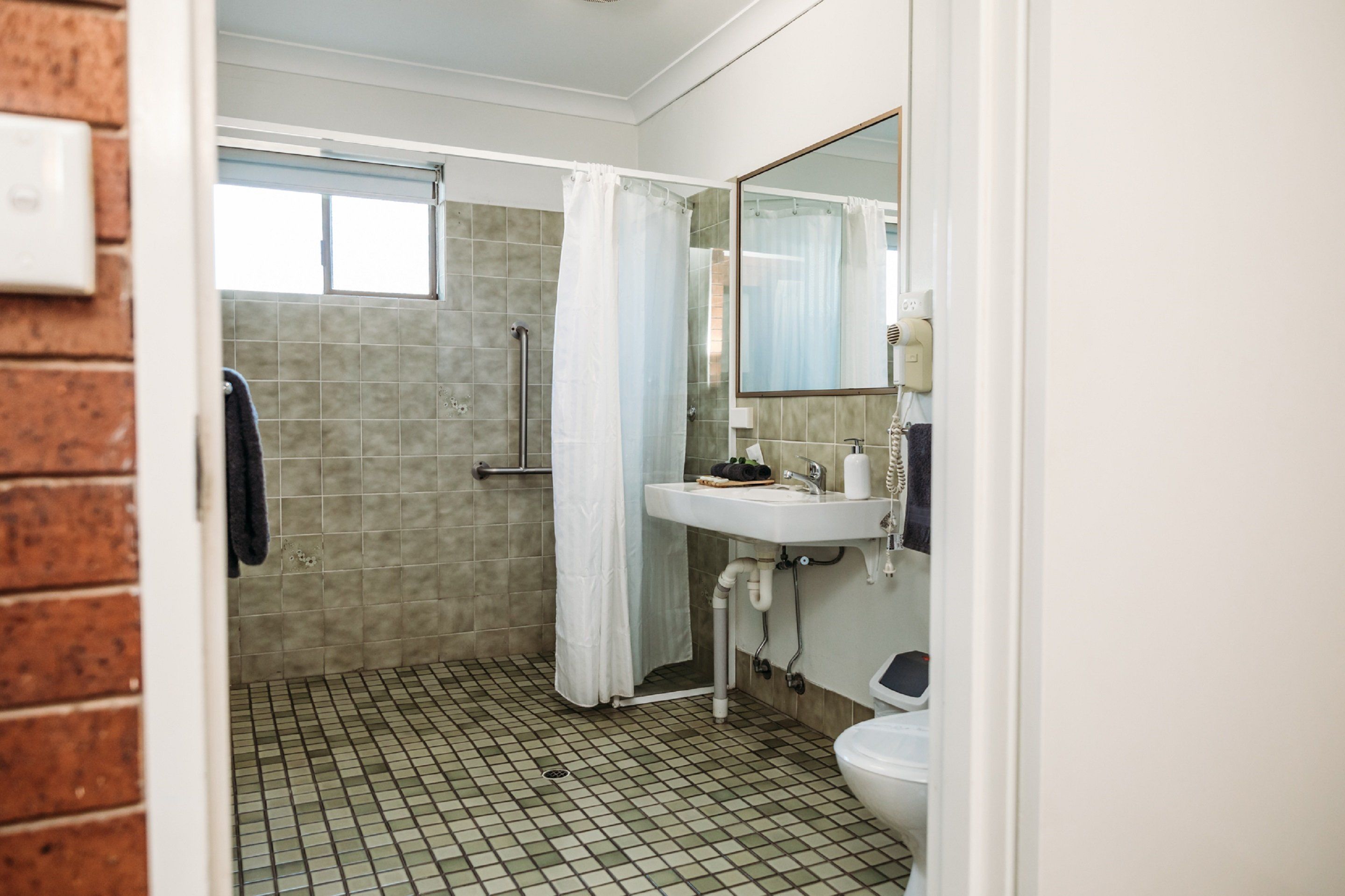 Une salle de bain avec une douche, un lavabo et des toilettes.