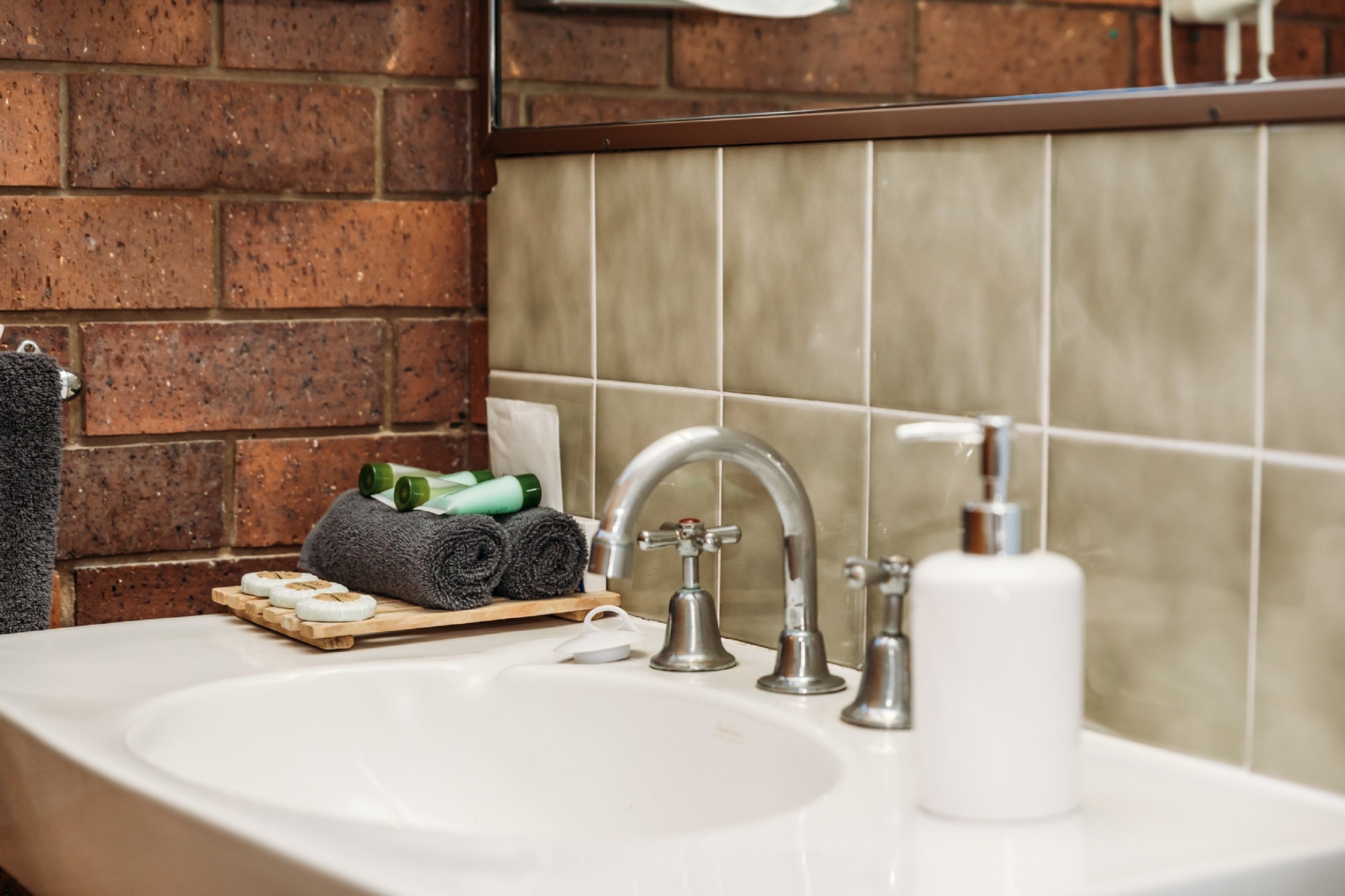 A bathroom with a sink, a mirror, and a towel rack.