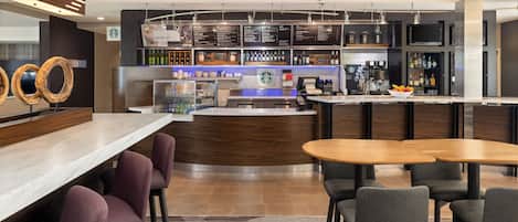 Zona de bar moderna con mostrador, asientos y tablero de menú.