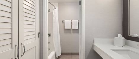 A bathroom with a shower, a toilet, and a sink.