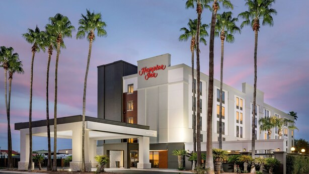 A modern hotel with a prominent "Hampton Inn" sign, featuring a clean architectural design with a flat roof and multiple floors. - Hampton Inn Laredo (Laredo)