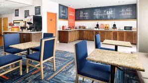 A modern cafe with seating, a coffee machine, and a chalkboard menu. - Hampton Inn Laredo (Laredo)