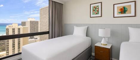 Habitación de hotel con cama, mesitas de noche, una lámpara y dos cuadros en la pared.