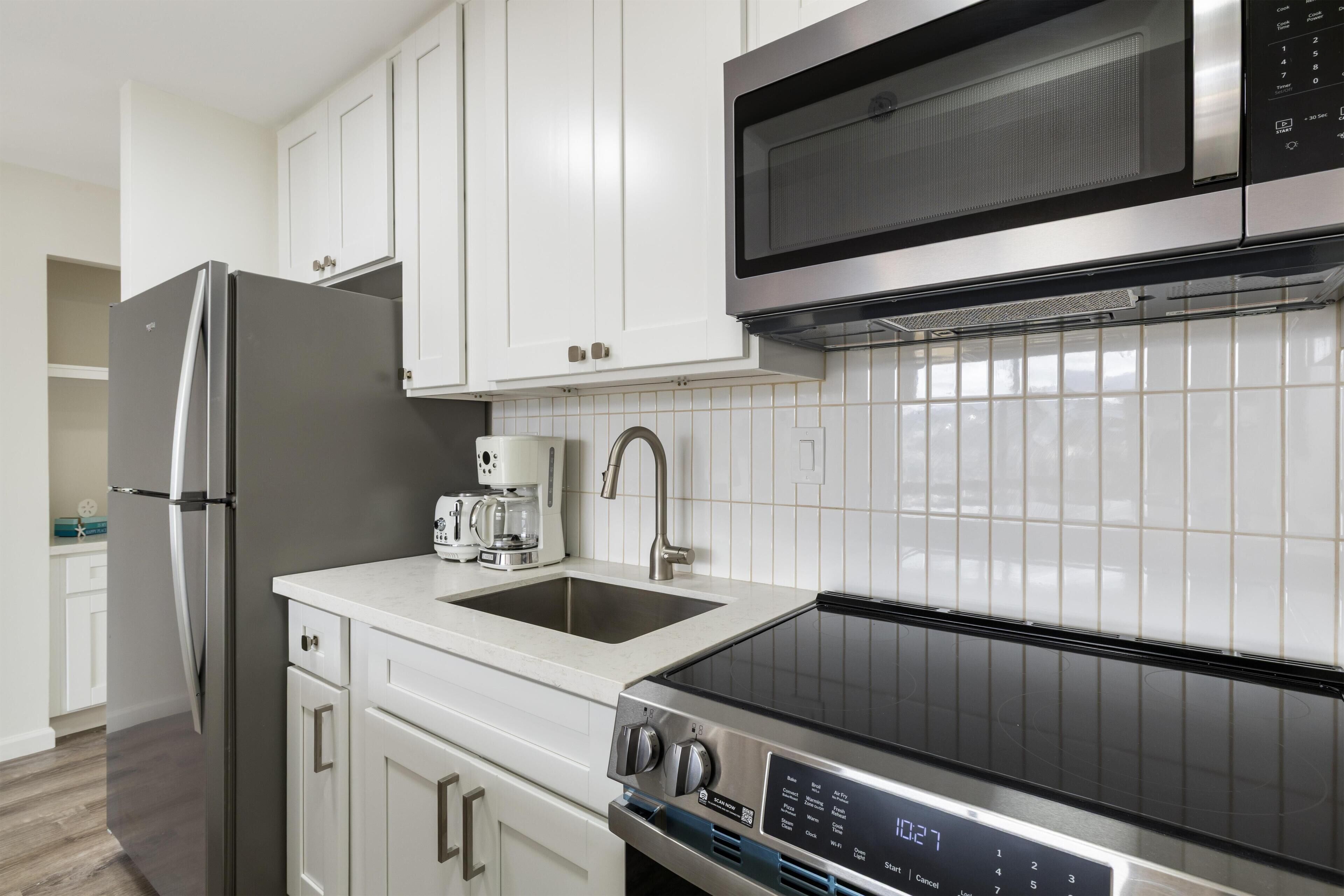 A modern kitchen with stainless steel appliances, a microwave, and a built-in oven.