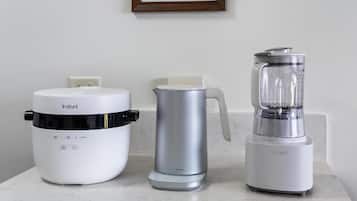 A kitchen countertop with an Instant coffee maker, a silver electric kettle, and a Cuisinart blender.