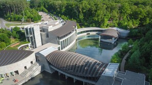 A modern architectural complex with a central water feature, surrounded by lush greenery. - Holiday Inn Springdale/Fayetteville Area by IHG (Springdale)