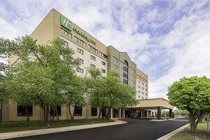 Un hotel Holiday Inn Express con un diseño moderno, que presenta un techo plano y una entrada central.