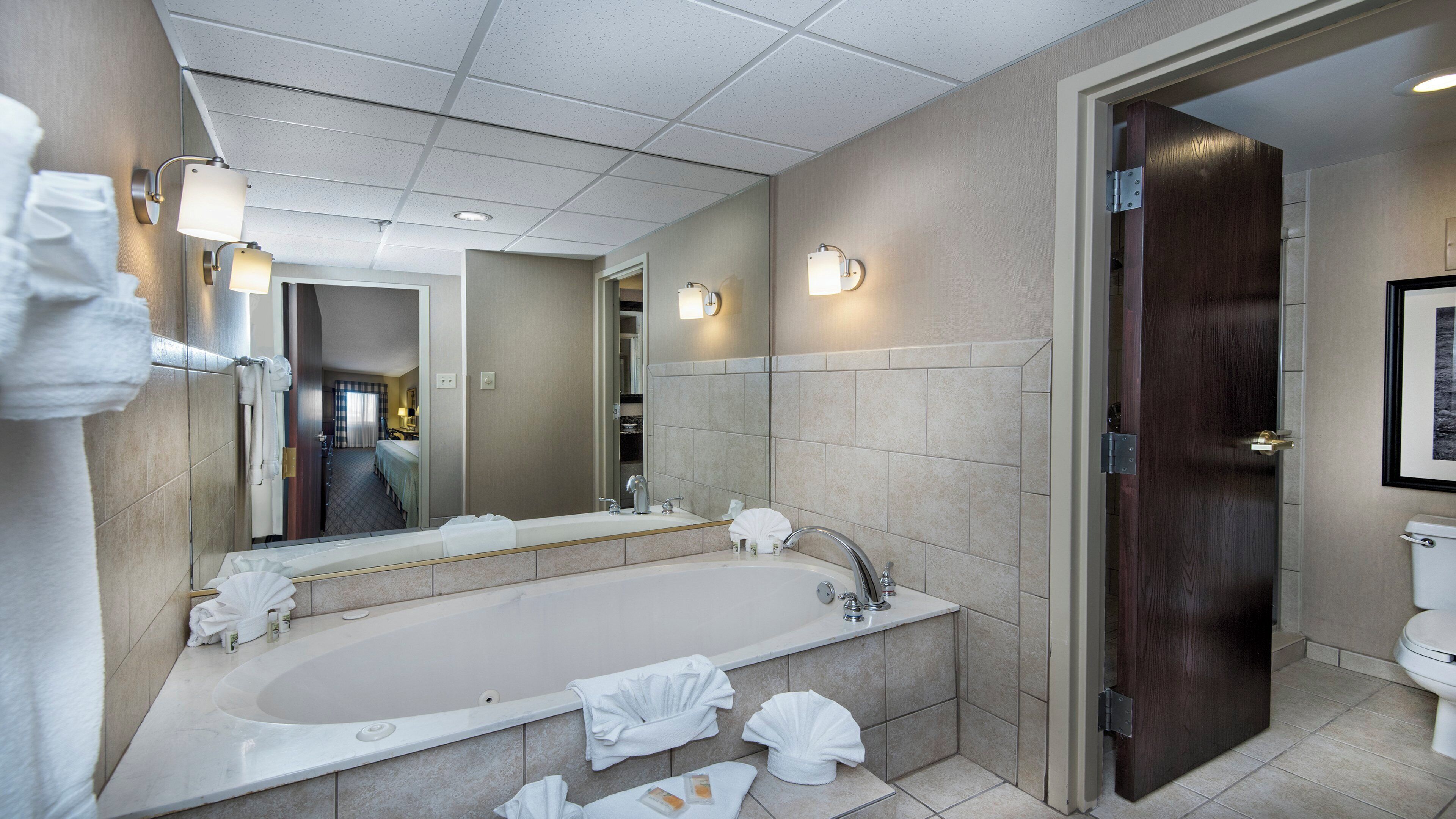 Un baño de hotel con una bañera grande, un lavabo y un inodoro.