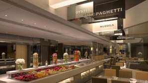 A modern restaurant with a buffet area featuring a variety of fruits and vegetables. - Stanford Hotel (Kowloon)