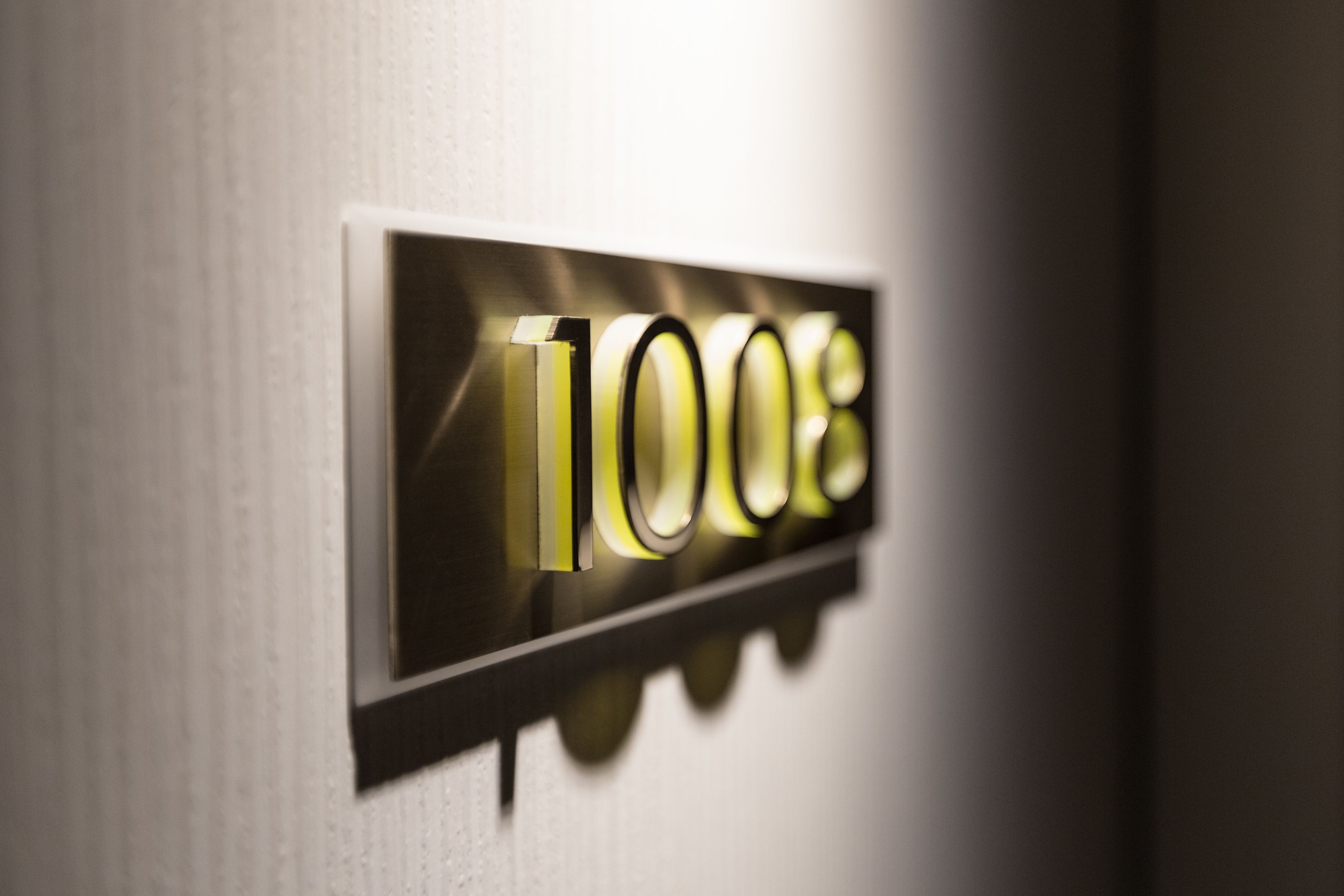 A close-up of a metallic sign with the number "1008" illuminated.