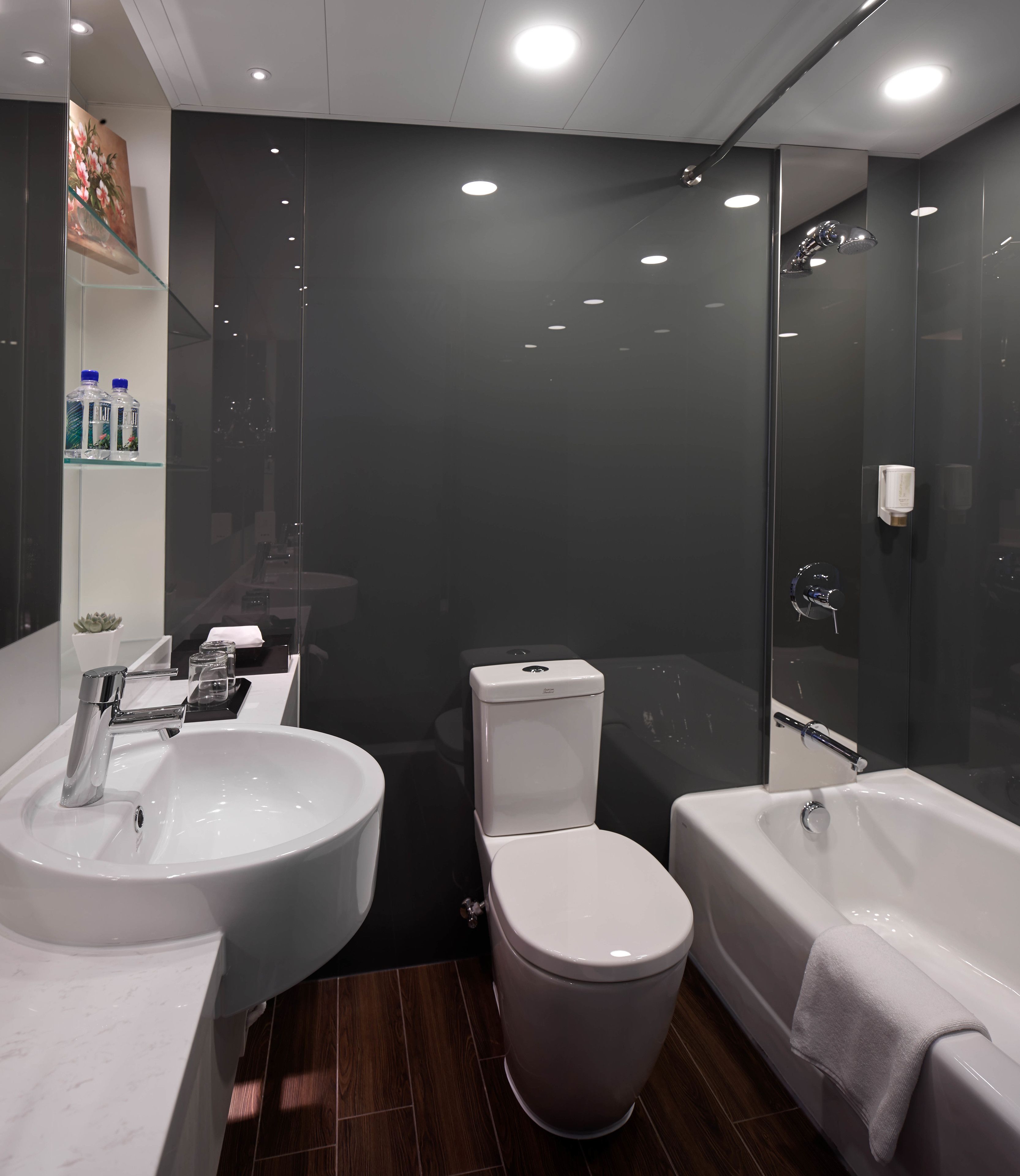 A modern bathroom with a white sink, toilet, and bathtub.