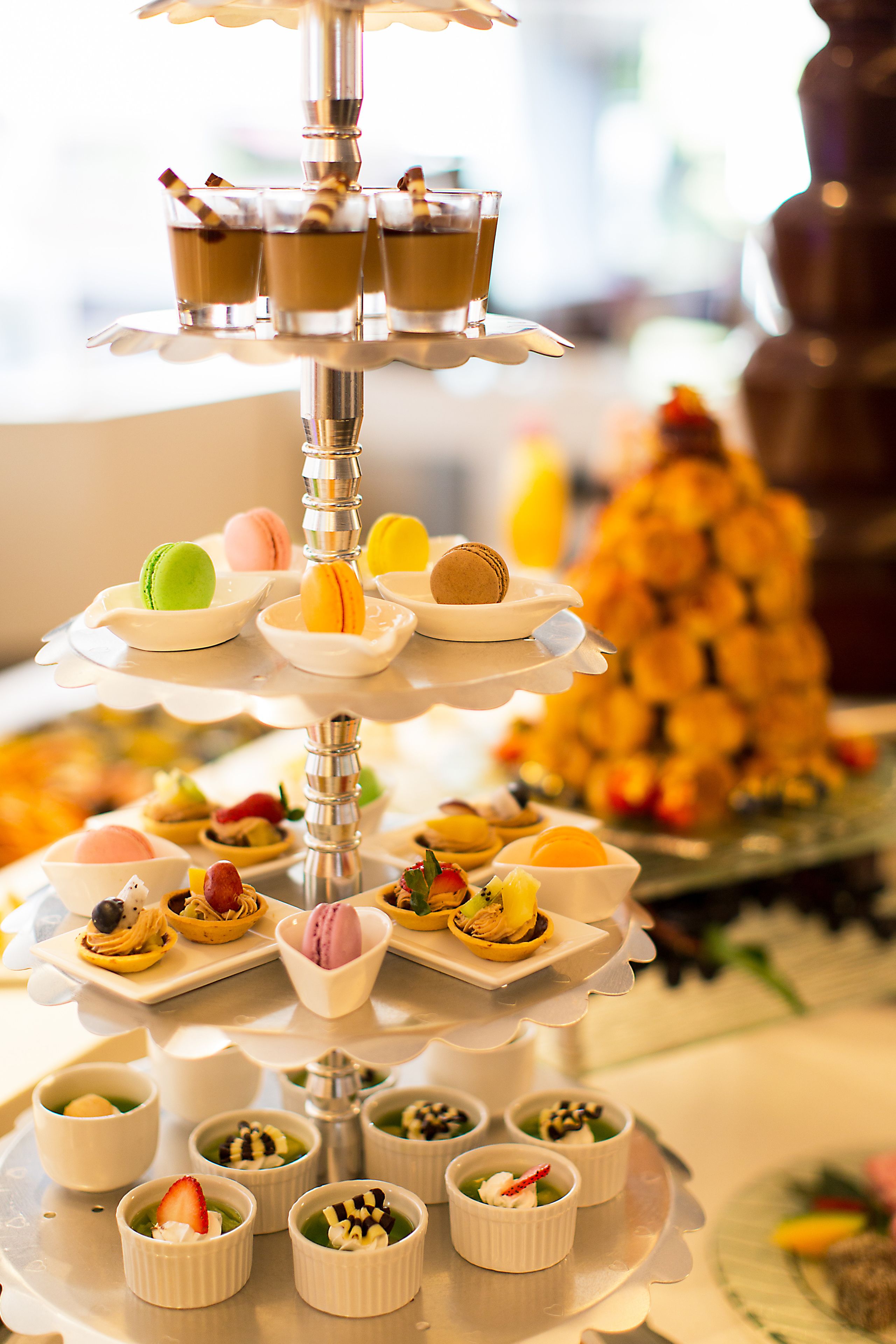A multi-tiered dessert display with various pastries and small dishes.