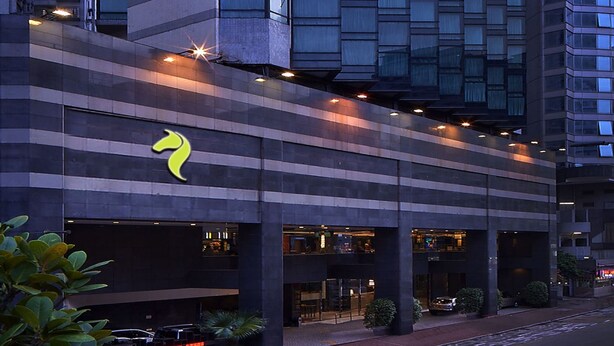 A modern hotel with a unique architectural design, featuring a prominent curved corner and multiple floors. - Stanford Hotel (Kowloon)