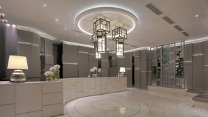 A modern lobby with a marble floor, a reception desk, and a unique circular ceiling design. - Stanford Hotel (Kowloon)